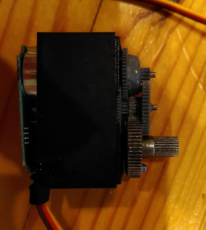 A picture of a plastic and metal geared servo with damaged teeth.