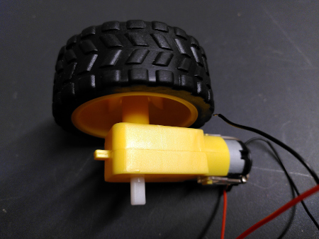 Picture of a small yellow platic motor and gearbox common in toy robotics.