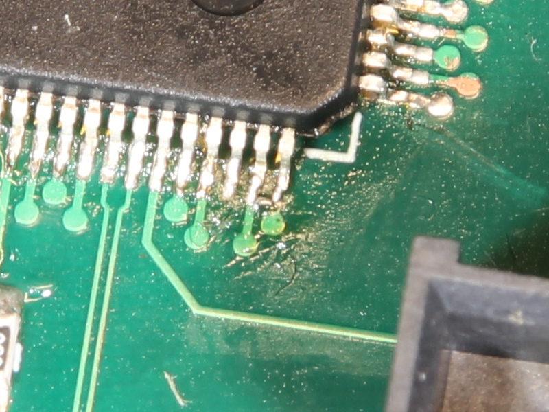 A tiny blob of solder between two pins on a large QFP chip.