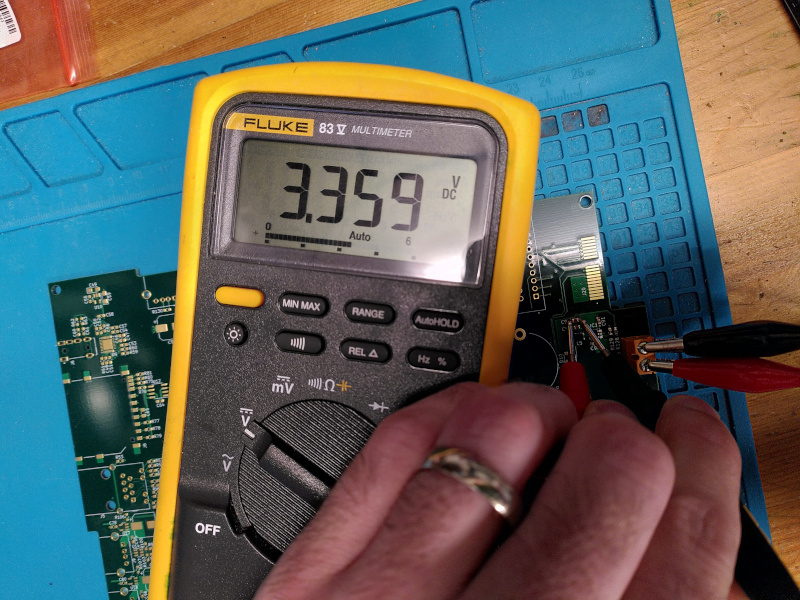 A multimeter reading a voltage of 3.359V